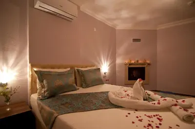 a bedroom with a bed with a baby on it at DEFNE OTEL in Sile