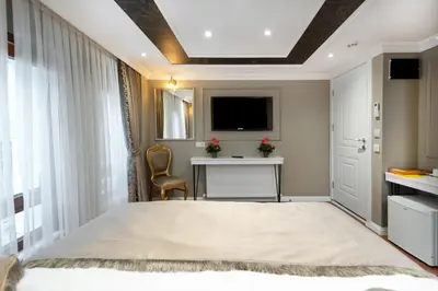 a bedroom with a bed and a desk and a tv at Azalea Mansion Oldcity in Istanbul
