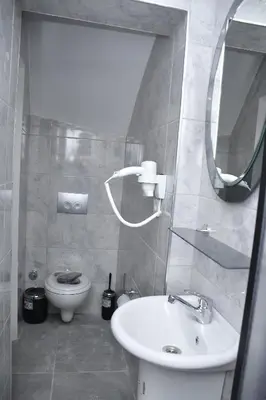 a bathroom with a sink and a toilet and a mirror at Hotel Arinna in Istanbul