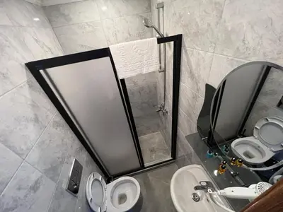 a bathroom with a shower and a toilet and a sink at Hotel Arinna in Istanbul
