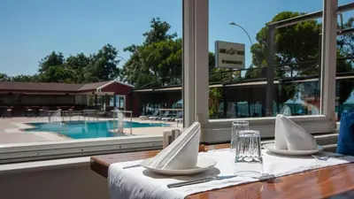 a table with white napkins on a table with a view of a pool at Lake Life Hotel in İznik