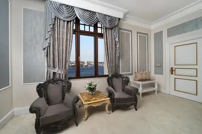 a living room with two chairs and a table and a window at Legacy Ottoman Hotel Istanbul Old City in Istanbul