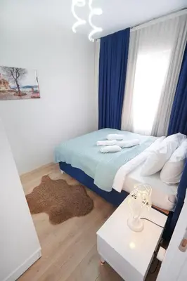 a small bedroom with a bed and a table at Classic Suite BH13 in Esenyurt