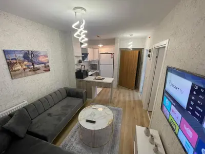 a living room with a couch and a table and a kitchen at Classic Suite SH17 in Esenyurt