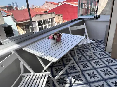 a white table on a balcony with flowers on it at Central Istanbul, Luxury 3BR, 4 min to Metro in Istanbul