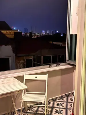 a chair and a table on a balcony at night at Central Istanbul, Luxury 3BR, 4 min to Metro in Istanbul