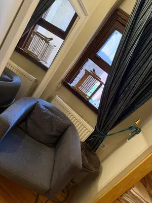 a living room with a chair and two windows at Fatih Balat tarihin içinden konut - 3 in Istanbul