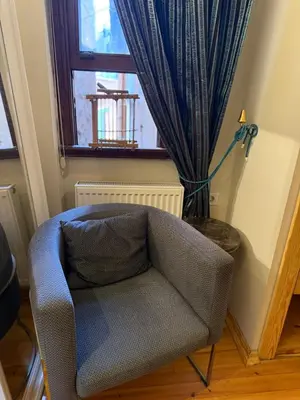 a blue chair in a room with a window at Fatih Balat tarihin içinden konut - 3 in Istanbul