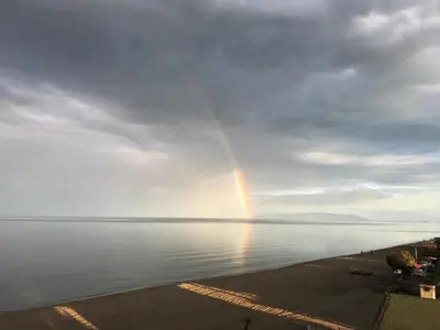 a rainbow in the sky over a body of water at NOVA PORT Boutique Hotel in Tekirdag