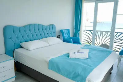 a bedroom with a large bed with a blue headboard at NOVA PORT Boutique Hotel in Tekirdag