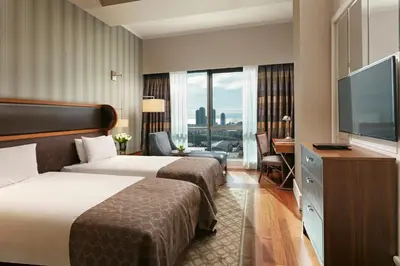 a hotel room with two beds and a flat screen tv at Titanic Business Kartal in Istanbul