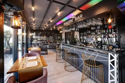 a restaurant with a bar with chairs and tables at Skalion Hotel in Istanbul
