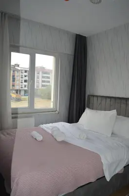 a bed with two towels on it with a window at Classic Suite AA7 in Esenyurt