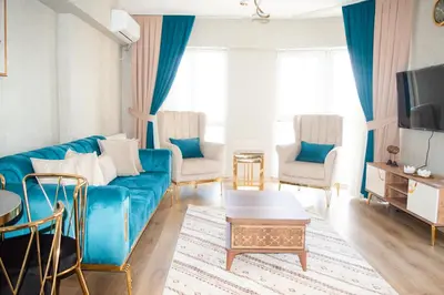 a living room with a blue couch and two chairs at King Suite AN33 in Esenyurt