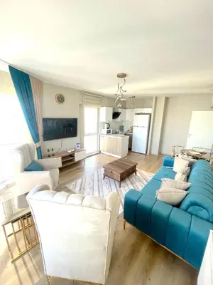a living room with a blue couch and white chairs at King Suite AN33 in Esenyurt