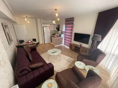 a living room with a couch and chairs and a television at King Suite SS2 in Esenyurt