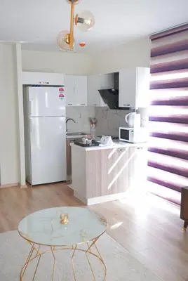 a kitchen with a table and a white refrigerator at King Suite SS2 in Esenyurt