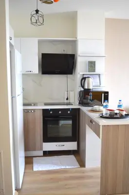 a kitchen with white cabinets and a black oven at Classic Suite MS33 in Esenyurt