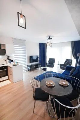 a living room with a blue couch and a table at King Suite MS5 in Esenyurt