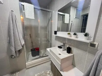 a white bathroom with a sink and a shower at King Suite AM2 in Esenyurt