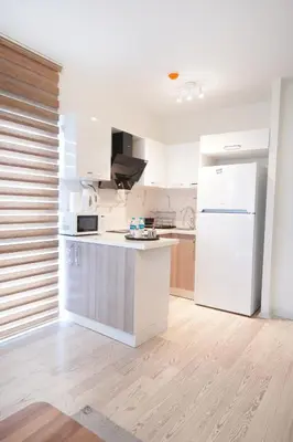 a kitchen with a white refrigerator and a counter at King Suite AM2 in Esenyurt