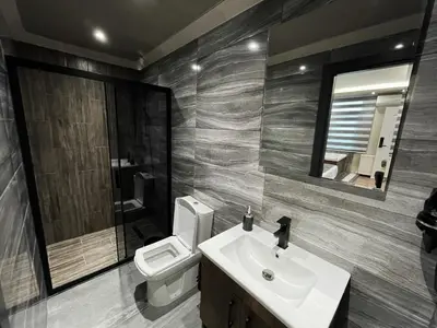 a bathroom with a sink and a toilet and a mirror at GRAND ÜSKÜDAR OTEL in Istanbul