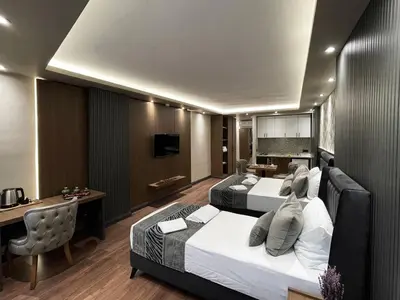 a hotel room with two beds and a desk at GRAND ÜSKÜDAR OTEL in Istanbul