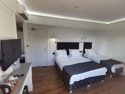 a hotel room with two beds and a flat screen tv at Efzen hotel in Istanbul