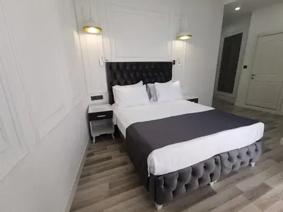 a bedroom with a large bed with a black headboard at Efzen hotel in Istanbul