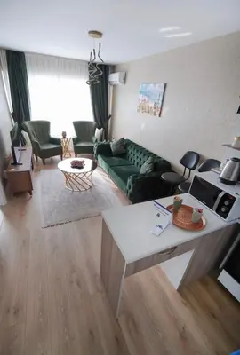a living room with a green couch and a table at Luxe Suite AI3 in Esenyurt