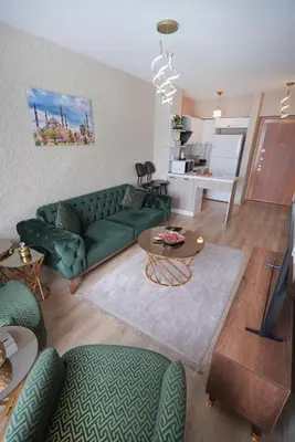 a living room with a green couch and a table at Luxe Suite AI3 in Esenyurt
