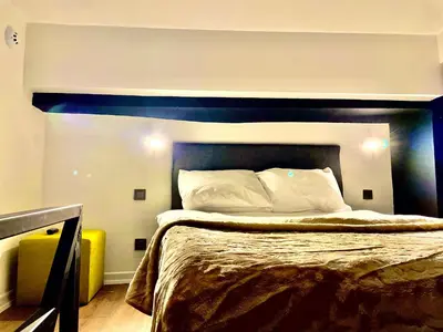 a bedroom with a large bed with a blue headboard at Mates Port Hotel in Istanbul