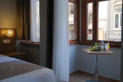 a bedroom with a bed and a table with a bowl of fruit at Adamantides Hotel in Istanbul