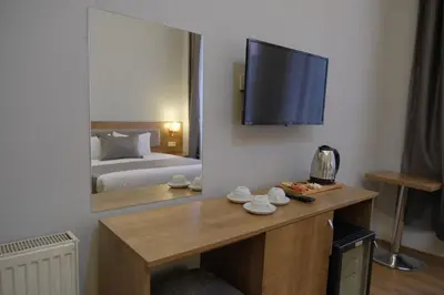 a hotel room with a bed and a desk with a television at Adamantides Hotel in Istanbul