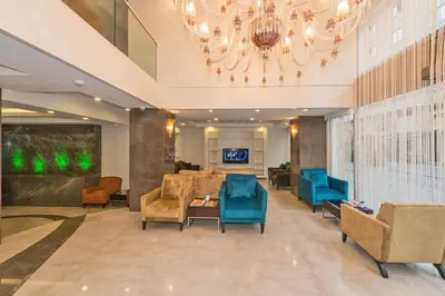 a lobby with blue chairs and a chandelier at Bisetun Hotel in Istanbul