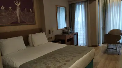a hotel room with a bed and a desk and window at Taximist Hotel in Istanbul