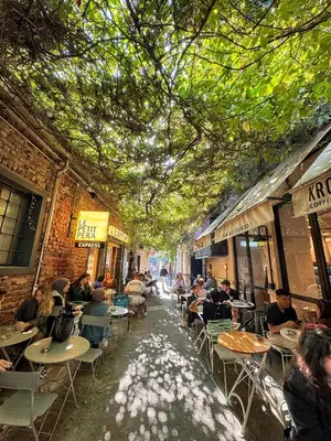 a group of people sitting at tables in an alley at Nomad Hostel Karaköy in Istanbul