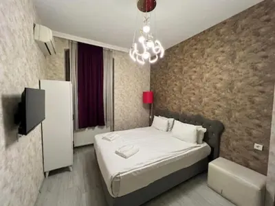 a small bedroom with a bed and a chandelier at Gran Brn Hotel Taksim in Istanbul