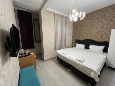 a bedroom with a bed and a television and a chandelier at Gran Brn Hotel Taksim in Istanbul