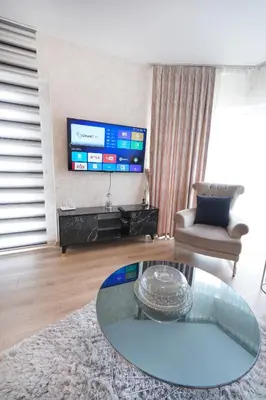 a living room with a table and a tv at King Suite AE8 in Esenyurt