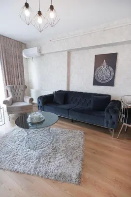 a living room with a blue couch and a table at King Suite AE8 in Esenyurt
