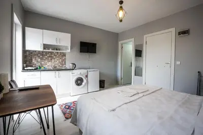 a bedroom with a bed and a table and a kitchen at Zelya İstanbul flats in Istanbul
