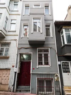 a gray building with a red door on a street at Zelya İstanbul flats in Istanbul