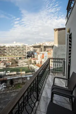 a balcony with two chairs and a view of a city at Zelya İstanbul flats in Istanbul