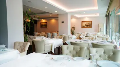 a dining room with white tables and chairs at AURA MARINA HOTEL in Istanbul