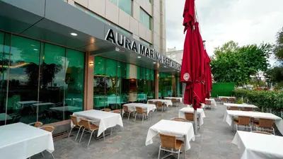 a restaurant with tables and chairs and a red umbrella at AURA MARINA HOTEL in Istanbul