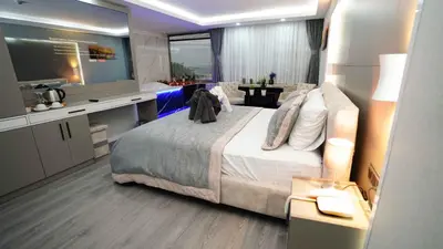 a bedroom with a bed and a desk and a television at AURA MARINA HOTEL in Istanbul