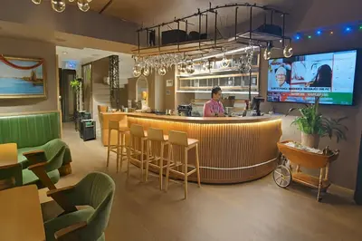 a man standing at a bar in a restaurant at Aleksandr Pera Hotel in Istanbul