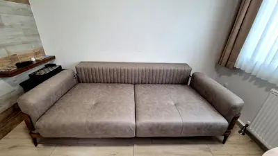 a brown couch in a living room with a window at Cihangir Flat in Istanbul