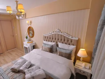 a bedroom with a large white bed with pillows at Divani Ali Hotel in Istanbul
